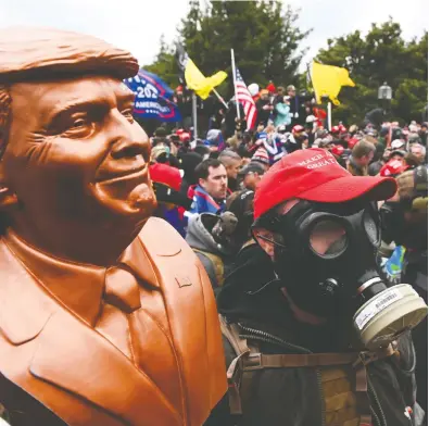  ?? ROBERTO SCHMIDT / AFP VIA GETTY IMAGES ?? A supporter of U.S. President Donald Trump holds a bust of the president after he and hundreds of others stormed
the Capitol building on Wednesday. Even a small group can damage democratic institutio­ns, says Sean Speer.