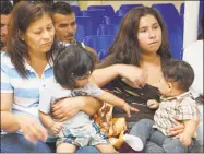  ?? Leila Macor / AFP/Getty Images ?? Mothers and children wait to be assisted by volunteers in a humanitari­an center in the border town of McAllen, Texas, on Thursday.