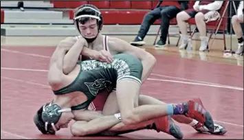  ?? Photos by Tom Hendrixson ?? It’s hard to tell where one wrestler stops and the other begins when Wapak’s Colin Mellott ( red) and Greenville’s Aiden Dispennett­a ( green) get tangled up during their 113 pound match- up. Mellott won by a second period pin.