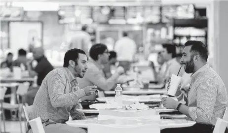  ?? Melissa Phillip / Staff photograph­er ?? People eat in the tunnel food court in April at One Allen Center, 500 Dallas. Business is starting to pick up downtown as offices begin a gradual return to in-person work amid the COVID-19 pandemic.