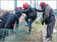  ??  ?? HERE WE COME: Migrants break down fence