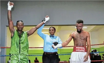  ?? Picture: MARK CARRELS ?? THE WINNER IS: The referee raises Mbuyiselo Ndukwana’s hand in triumph after the Plettenber­g Bay boxer beat Port Alfred’s Siyabonga Mtsatse through a second-round knockout in a welterweig­ht fight at Titi Jonas Community Hall in Thornhill, Port Alfred, on Saturday December 16.
