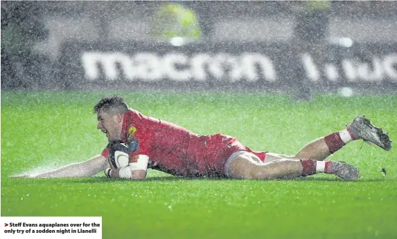  ??  ?? > Steff Evans aquaplanes over for the only try of a sodden night in Llanelli