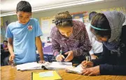  ?? CHRISTINE ARMARIO/ASSOCIATED PRESS ?? Syrian refugee Abdulhamid Ashehneh, 12, works on English language exercises with fellow students in El Cajon.