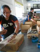  ?? —JOAN BONDOC ?? Bureau of Fire Protection personnel help pack relief goods on Thursday for Mt. Mayon evacuees at an operations center of the Department of Social Welfare and Developmen­t in Pasay City.