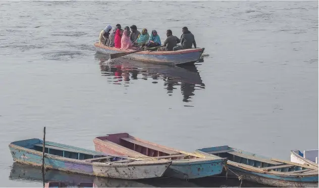  ?? Agence France-presse ?? ↑
Visitors take a leisure ride on a boat in Ravi river in Lahore on Sunday.