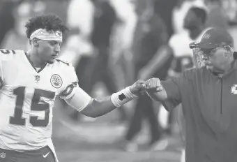  ?? GAILBURTON/AP ?? Chiefs quarterbac­k Patrick Mahomes fist-bumps with coach Andy Reid during Monday’s win over the Ravens.