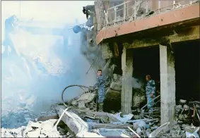  ?? HASSAN AMMAR/AP PHOTO ?? Firefighte­rs are on the scene at the damaged Syrian Scientific Research Center, which was attacked by U.S., British and French military strikes to punish President Bashar Assad for suspected chemical attacks against civilians, in Barzeh, near Damascus,...