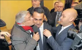  ?? AP ?? 5Star Movement leader Luigi Di Maio (centre) is kissed by a journalist as he arrives for a press conference. The antiestabl­ishment movement emerged as the single largest party in the polls.