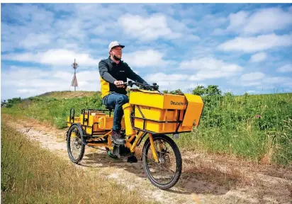  ?? FOTO: SINA SCHULDT/DPA ?? Postbote Andre Krandick verteilt Briefe und Pakete auf der ostfriesis­chen Insel Baltrum.