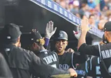  ??  ?? Rockies right fielder Carlos Gonzalez exchanges high-fives in the dugout after his home run during the fourth inning Tuesday night against the Arizona Diamondbac­ks. John Leyba, The Denver Post