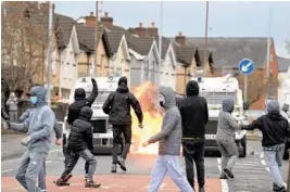  ?? CHARLES MCQUILLAN/GETTY ?? Amid a recent spate of violence, people attack police vehicles Thursday near gates dividing nationalis­t and loyalist communitie­s in Belfast, Northern Ireland.