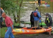  ?? MARIAN DENNIS – DIGITAL FIRST MEDIA ?? As sojourners get to Royersford for a midday break, they help each other carry canoes and kayaks onto the bank.