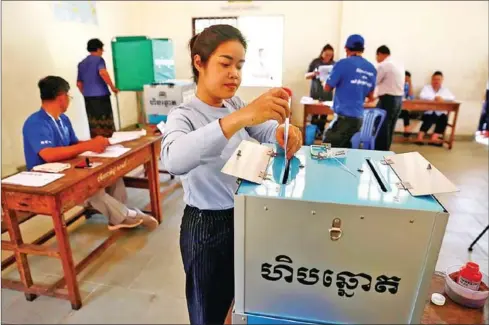  ?? HONG MENEA ?? A woman votes at a polling station in Phnom Penh’s Chamkarmon district in 2019.