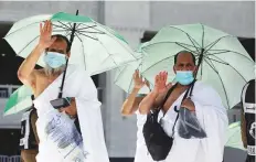  ?? AP ?? ■ Many pilgrims arriving in Makkah carried umbrellas to protect themselves from the scorching summer heat.