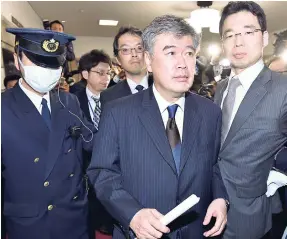  ??  ?? Japan’s Vice Finance Minister Junichi Fukuda (centre) leaves his ministry in Tokyo yesterday.