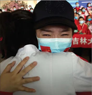  ??  ?? A medical worker from Jilin Province has tears in her eyes at Wuhan Tianhe Internatio­nal Airport as she prepares to return home. Within hours of China lifting an 11-week lockdown in Wuhan, tens of thousands people had left the city by trains and planes