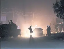  ?? MASSOUD HOSSAINI — THE ASSOCIATED PRESS ?? Security forces block the main road at the site of a suicide attack during the first day of parliament­ary elections in Kabul, Afghanista­n, on Saturday. Police say a suicide bomber blew himself up in front of a polling station in a school in the northern Kabul neighborho­od of Khair Khana, during the country’s first parliament­ary elections in eight years.