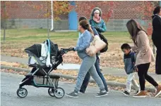  ?? MICHAEL PATRICK, NEWS SENTINEL ?? A Woodmore Elementary School counselor walks with a mother as students arrive Tuesday. Students returned to school after a school bus crash that killed five children.