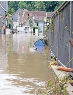  ?? FOTOS: MEUTER (2), MELCHOIR, STADT-SPARKASSE ?? Am Tag nach dem Hochwasser war die Eschbachst­raße in Burg nur zu erahnen. Inzwischen geht das Wasser wieder zurück.