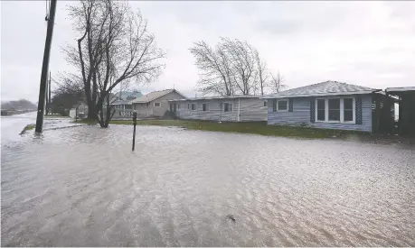  ?? DAN JANISSE ?? Water surrounds cottages along Erie Shore Drive in Chatham-kent on Wednesday as high winds and waves pounded the area.