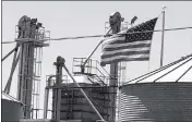  ?? PHOTO BY BLAKE HERZOG/YUMA SUN ?? A FLAG BLOWS IN THE WIND TUESDAY above the silos at Barkley Seed, 1818 S. Letvin Ave., Yuma.