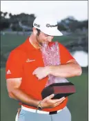  ?? Chris Carlson ?? The Associated Press Jon Rahm poses with the trophy after winning the Careerbuil­der Challenge in a four-hole playoff with Andrew Landry on Sunday in La Quinta, Calif.