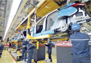  ?? — Reuters ?? Workers assemble vehicles at a plant of Changan Ford, a joint venture between Changan Automobile and Ford Motor Company, in Harbin, Heilongjia­ng province, China.