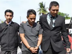 ??  ?? Mohamad Romzi (centre) pleads not guilty to the CBT charges. — Bernama photo