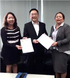  ??  ?? Lo (centre) and Fong (left) hand over the applicatio­n and letters to Georgina.