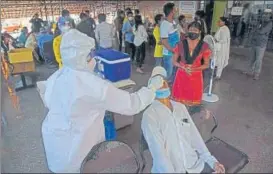  ?? BACHCHAN KUMAR/HT PHOTO ?? A healthcare worker collects swab samples at NMMC'S Meenatai Thackeray Hospital, Nerul, on Thursday.