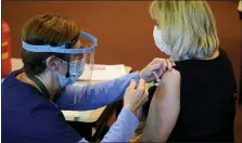  ?? MATT SLOCUM - THE AP ?? Pat Moore, left, with the Chester County, Pa., Health Department, administer­s the Moderna COVID-19 vaccine to Ann Yeager, a school district dental hygienist, at the Chester County Government Services Center, Tuesday, Dec. 29, in West Chester.