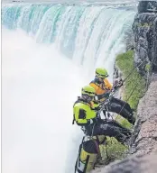  ?? BOB TYMCZYSZYN THE ST. CATHARINES STANDARD ?? Niagara Falls firefighte­rs Rob Kriter and Dan Murphy prepare for their decent as emergency personnel from the Niagara and surroundin­g area were rappelling at the brink of the Horseshoe Falls in Niagara Falls.