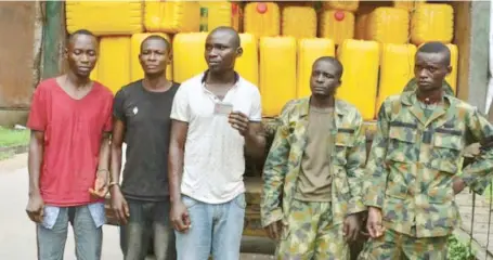  ?? Photo: Eugene Agha ?? Two dismissed soldiers and their collaborat­ors, during their parade for allegedly hijacking a truck load of vegetable oil in Lagos