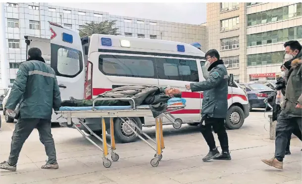  ?? FOTO: AP ?? Medizinisc­hes Personal schiebt einen Mann an einem Krankenwag­en in der nordchines­ischen Provinz Hebei vorbei.