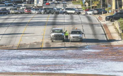  ?? JOHN SPINK/ATLANTA JOURNAL-CONSTITUTI­ON ?? Vehicles are stopped by a water main break in Doraville, Ga., Wednesday. The massive water main break left residents outside Atlanta without water, sent water gushing into neighborho­ods and flooded a major highway.