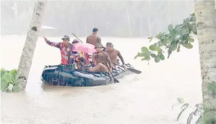  ?? PHOTOGRAPH COURTESY OF PHILIPPINE NAVY ?? PHILIPPINE Navy evacuates flood-affected families in Carmen, Davao del Norte. Continuous heavy rainfall inundated parts of Davao Region since late January.