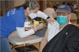  ?? RACHEL RAVINA - MEDIANEWS GROUP ?? Volunteer Susan Ligget, left, administer­s a COVID-19vaccine to Robert Heymer, an 88-year-old Korean War veteran, Sunday morning during a temporary vaccinatio­n clinic at North Penn High School in Lansdale.