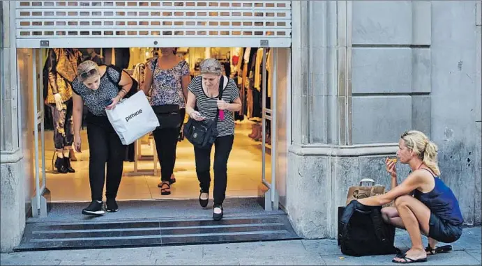  ?? LAURA GUERRERO ?? La peor hora para cerrar. Un comercio del Portal de l’Àngel de Barcelona baja la persiana a las seis de la tarde obligado por la normativa municipal