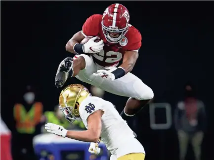  ?? GARY COSBY/USA TODAY SPORTS ?? Alabama running back Najee Harris leaps over Notre Dame cornerback Nick Mccloud on a first-down run Friday in the Rose Bowl in Arlington, Texas.
