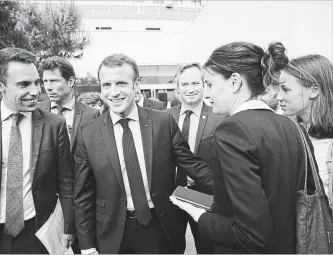  ?? CHRISTOPHE MORIN BLOOMBERG ?? French President Emmanuel Macron, second left, reacts as he walks at the Organizati­on for Economic Co-operation and Developmen­t (OECD) forum in Paris on Wednesday.