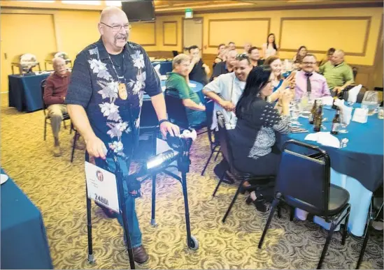  ?? Photograph­s by Michael Owen Baker For The Times ?? FORMER officer Harold Marinelli tests out his retirement gift, a walker with a police light, during a farewell party in March. His patrol partner will retire next year.
