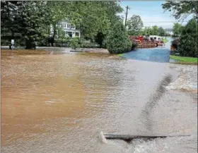  ?? TOM KELLY III — FOR DIGITAL FIRST MEDIA ?? A swollen Sprogel’s Run overflowed from Monday morning’s torrential rains and not only flooded Sunnybrook Road, forcing its closure, it also flooded the grounds and parking lots of the Sunnybrook Ballroom.