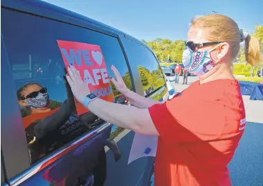  ?? PAULW. GILLESPIE/CAPITAL GAZETTE PHOTOS ?? MacArthur Middle School teacher Clair Cozad prepares a car Monday for a caravan organized by the TAAAC teachers union.