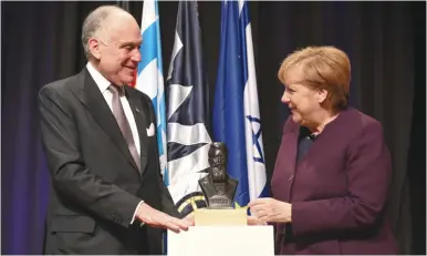  ?? (Shahar Azran) ?? WJC PRESIDENT Ronald S. Lauder presents German Chancellor Angela Merkel with the Theodor Herzl Award.