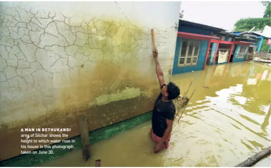  ?? RITU RAJ KONWAR ?? A MAN IN BETHUKANDI area of Silchar shows the height to which water rose in his house in this photograph taken on June 30.