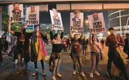  ?? TSAFRIR ABAYOV/AP ?? Demonstrat­ors hold placards depicting right-wing lawmakers with Hebrew inscriptio­ns asking what they’re afraid of during a protest Saturday in Tel Aviv, Israel.