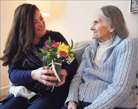  ?? Brian A. Pounds / Hearst Connecticu­t Media ?? Holly Batti, of Ridgefield, brings flowers last week to her mother, Gwenn Fiorito, who lives in memory care at Greens at Cannondale in Wilton.