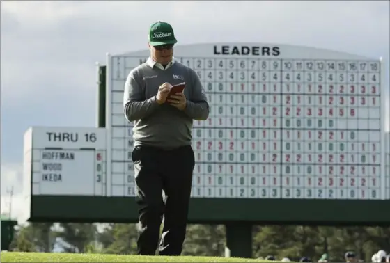  ?? CHARLIE RIEDEL, THE ASSOCIATED PRESS ?? Charley Hoffman marks his score after playing the 17th hole during the first round for the Masters golf tournament Thursday at Augusta, Ga. He finished with a 7-under 65.