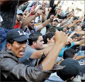  ?? AP/ MTI/ TAMAS KOVACS ?? Migrants shouting “Germany” and “U. N.” demonstrat­e Tuesday outside the Keleti Railway Station in Budapest after Hungary temporaril­y suspended all rail traffic there. Scuffles broke out as police forced hundreds of migrants out of the station and...